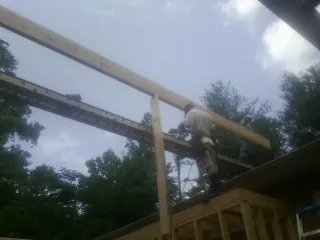 Carpenter setting a ridge beam over a new addition frame — Ice Dam Removal by Roofing Brothers in Kutztown