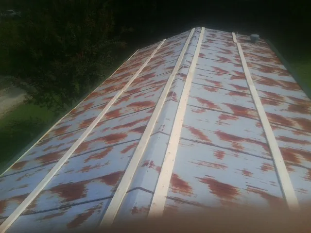 Rusted metal roof panels with new wood purlins before replacement — Storm Damage Roof Repair in Kutztown by Roofing Brothers