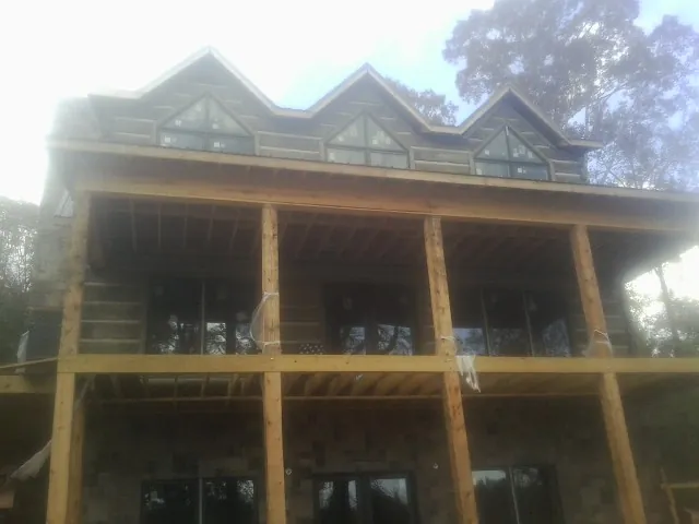 Dormers and porch framing on a large log home under construction — Roof Coating work by our crew in Kutztown