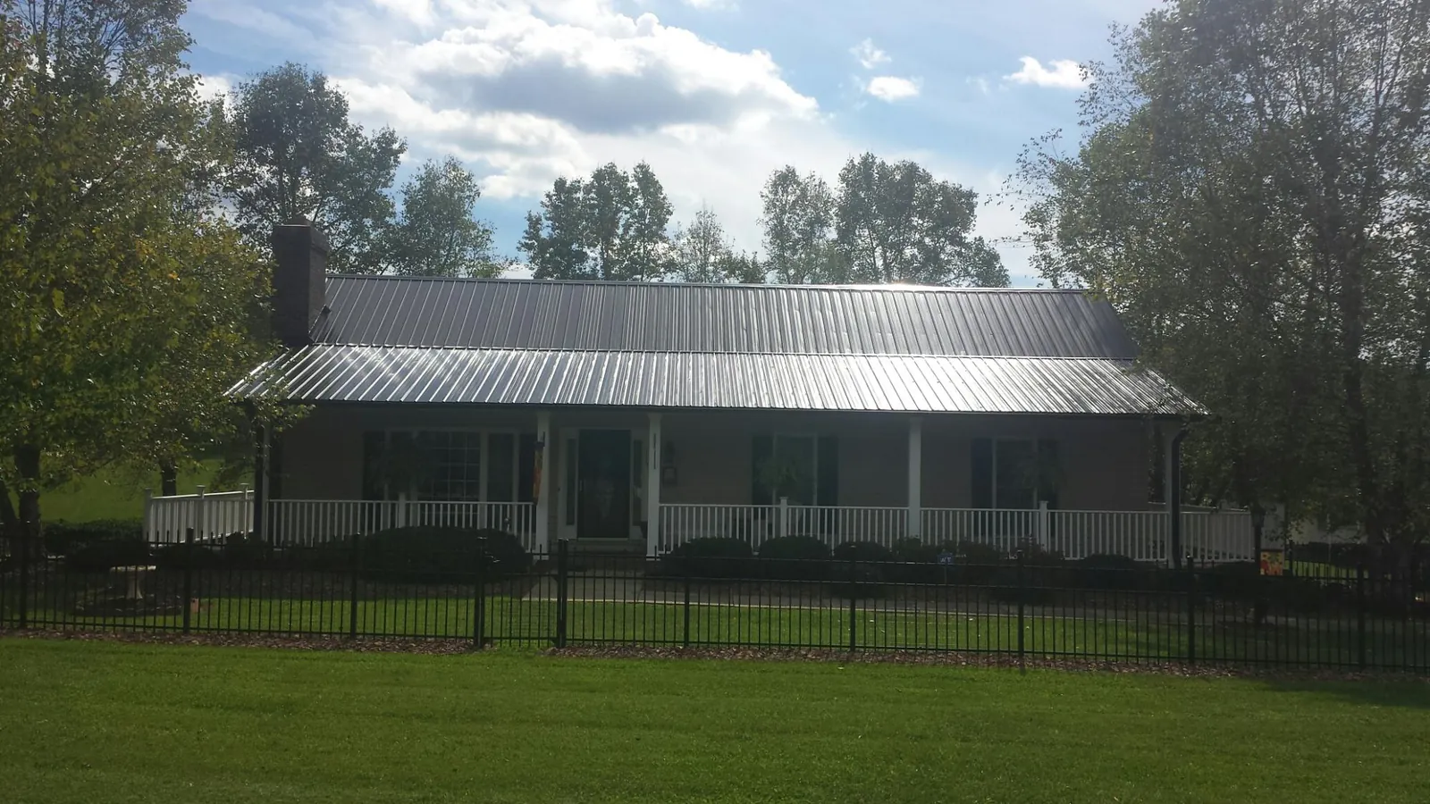 Gray metal roof on a brick ranch with a full width front porch — Gutter Guard Installation work by our crew in Kutztown