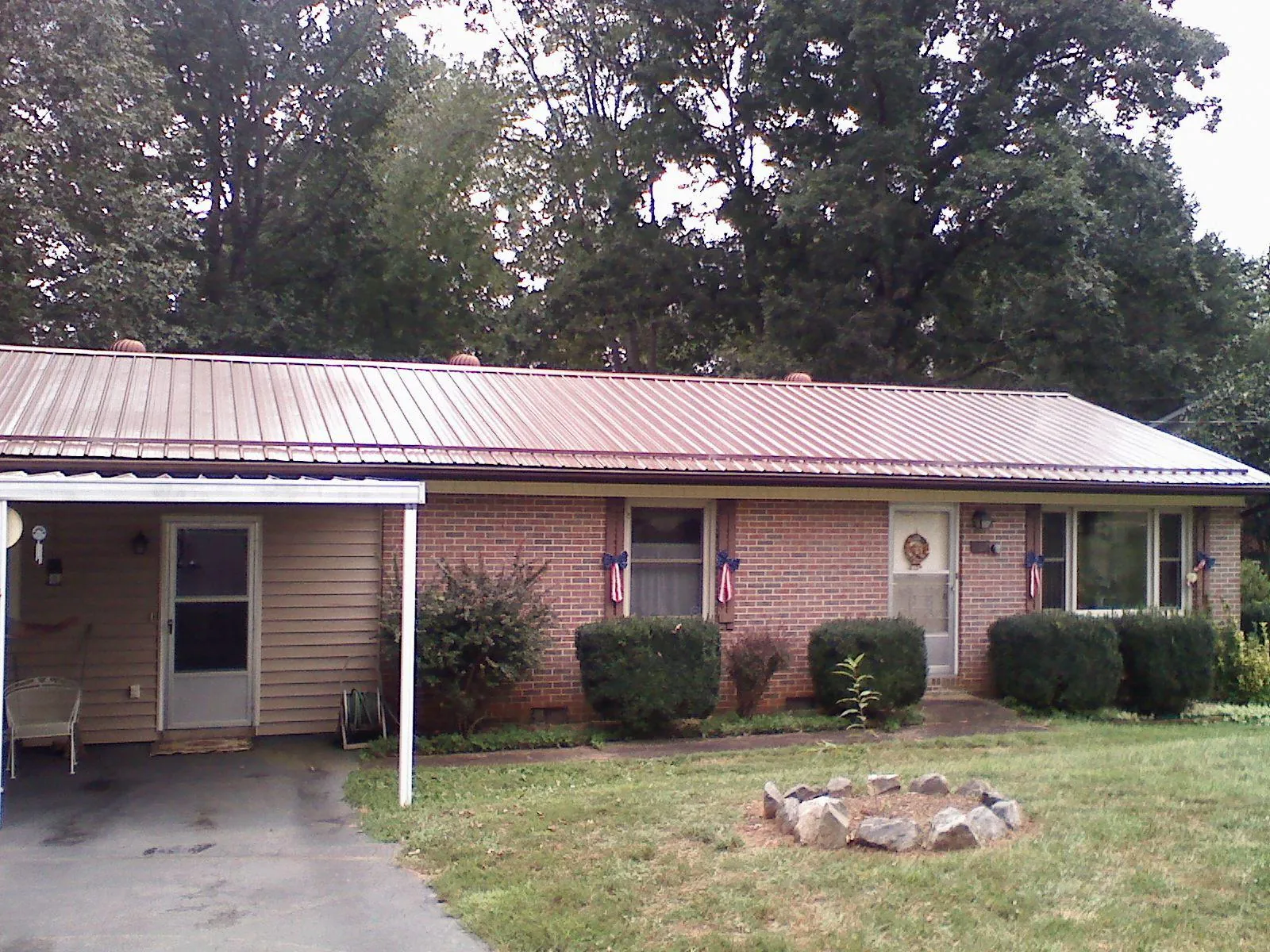 Bronze metal roof and carport on a brick ranch home — Roof Repair work by our crew in Kutztown