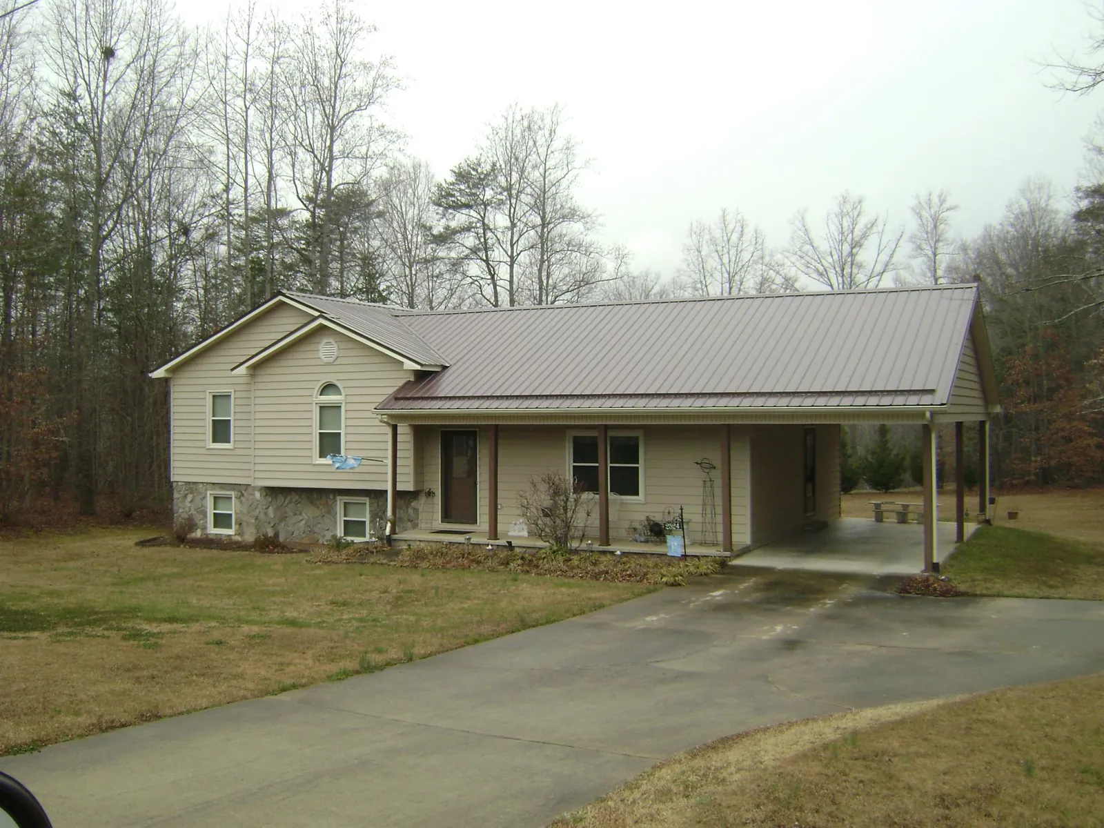 Brown metal roof on a tan split level home with an attached carport in Kutztown